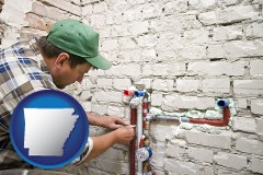 arkansas map icon and a plumbing contractor installing new water supply lines
