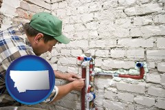montana map icon and a plumbing contractor installing new water supply lines