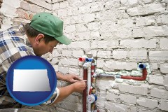 north-dakota map icon and a plumbing contractor installing new water supply lines