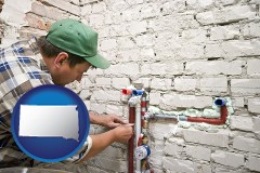 south-dakota map icon and a plumbing contractor installing new water supply lines